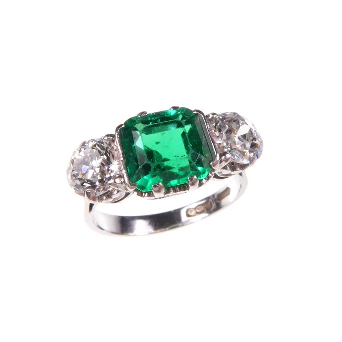 Emerald and diamond three stone ring, the octagonal step cut emerald between old round brilliant cut diamonds | MasterArt